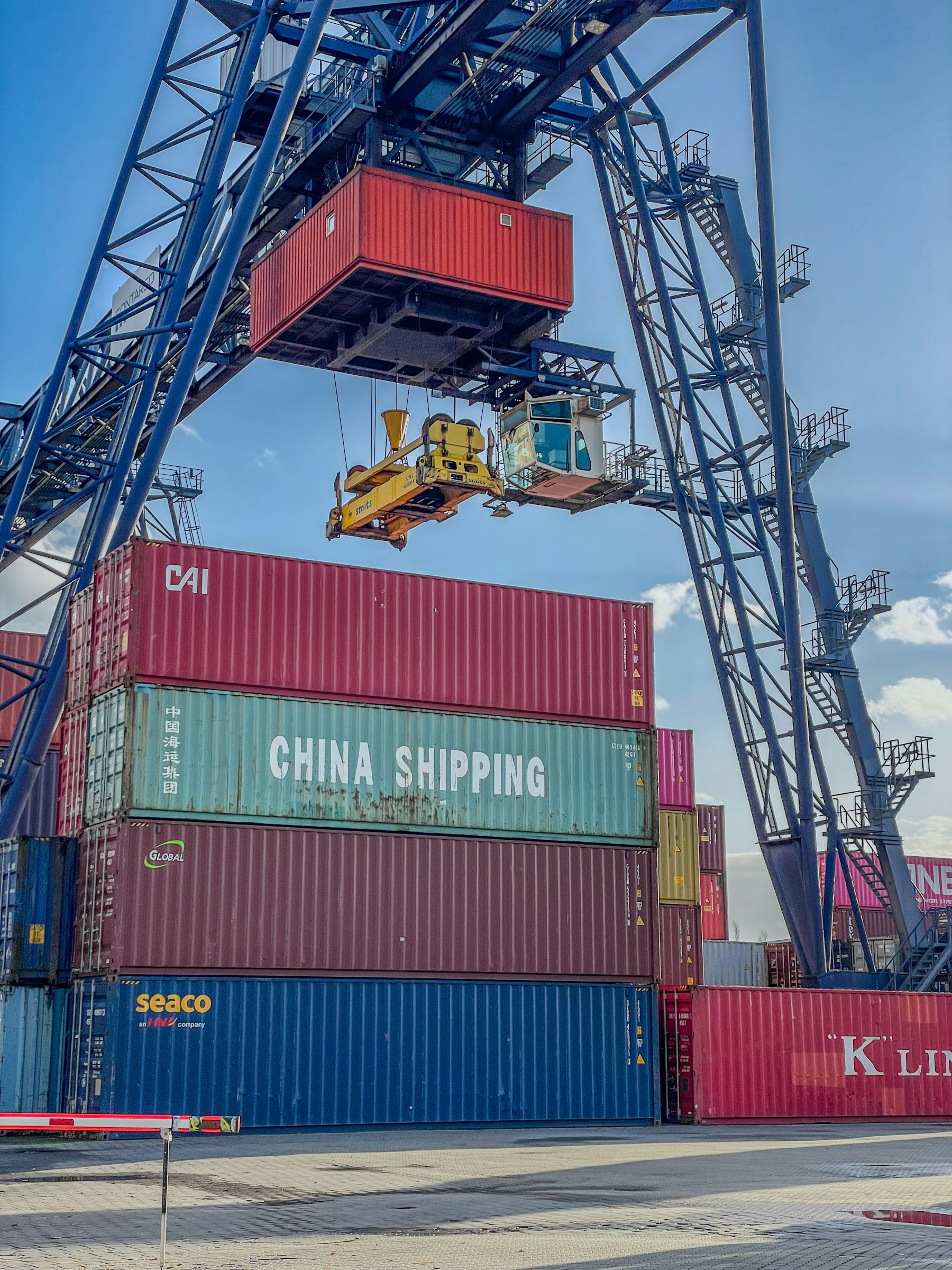 A crane is lifting a container onto a truck