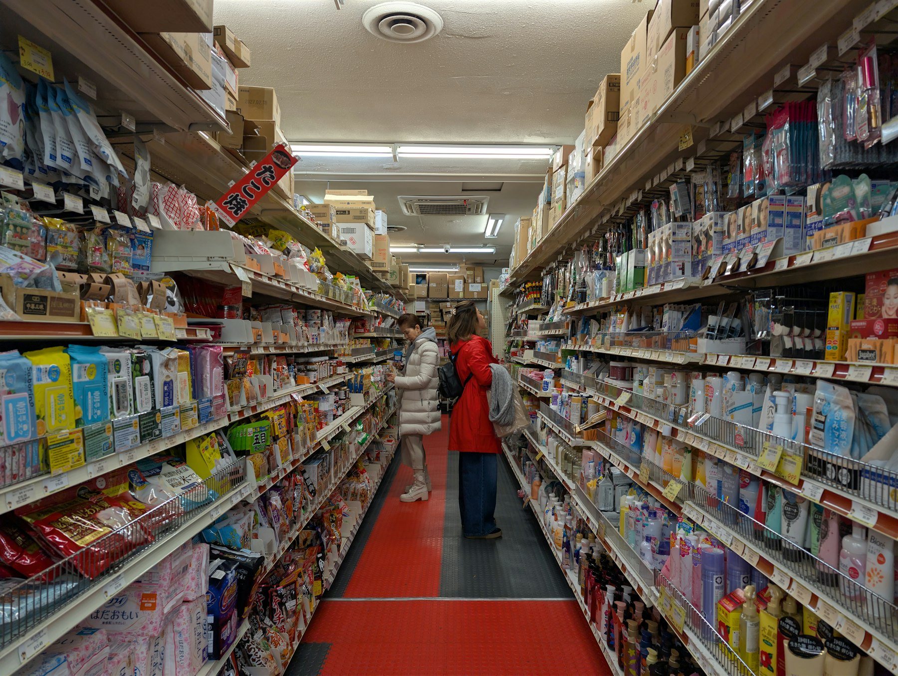 Aisle of a well-stocked retail store with many products