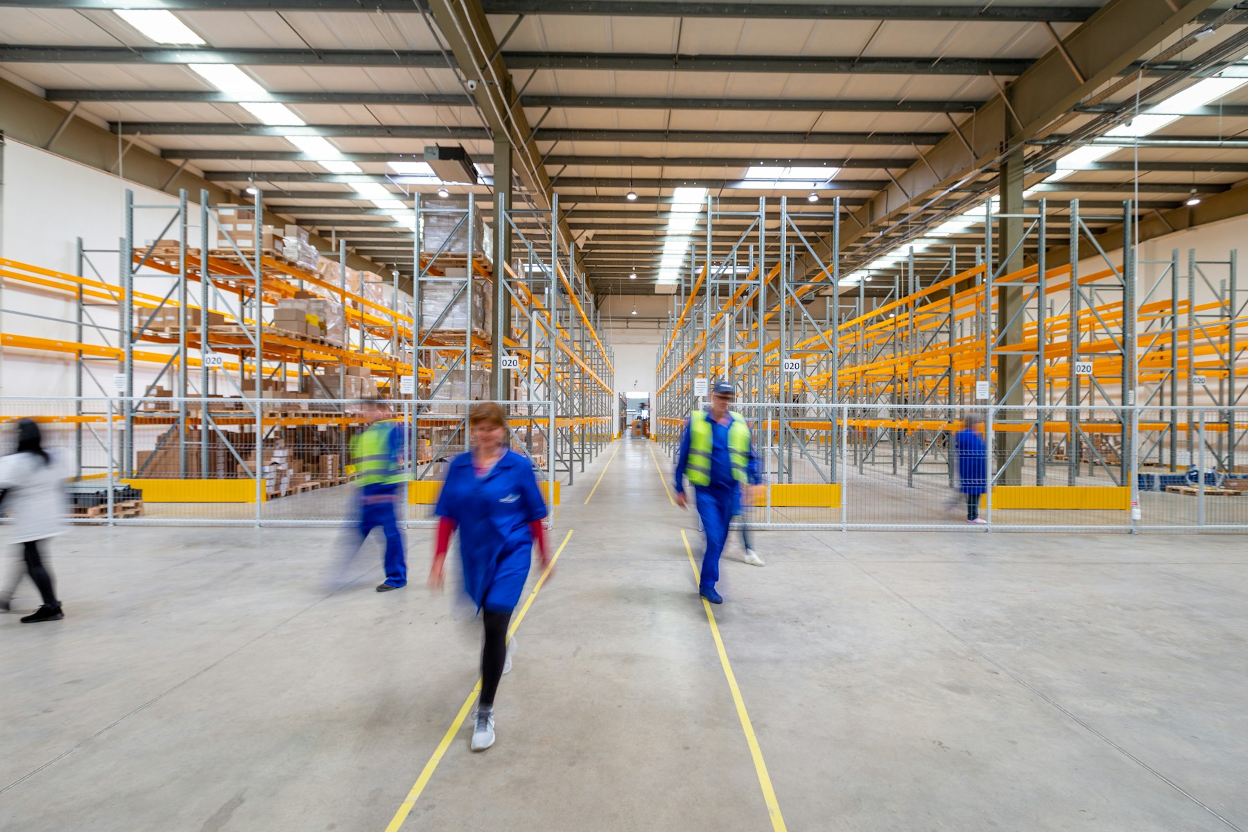 Workers walking through warehouse aisle